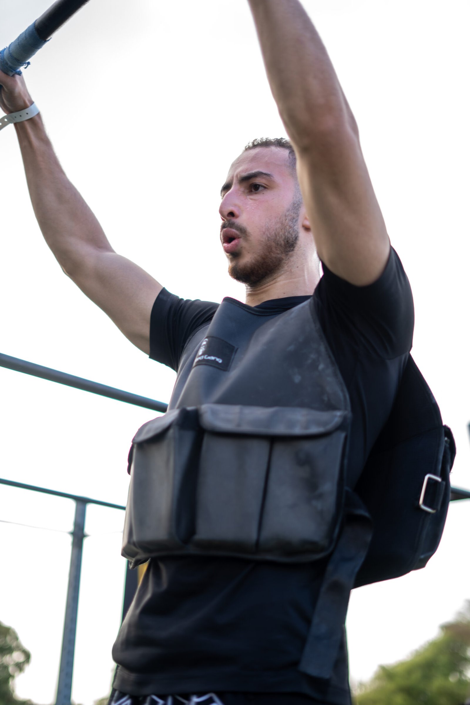 Man wearing a 10KG weighted vest during outdoor workout session.