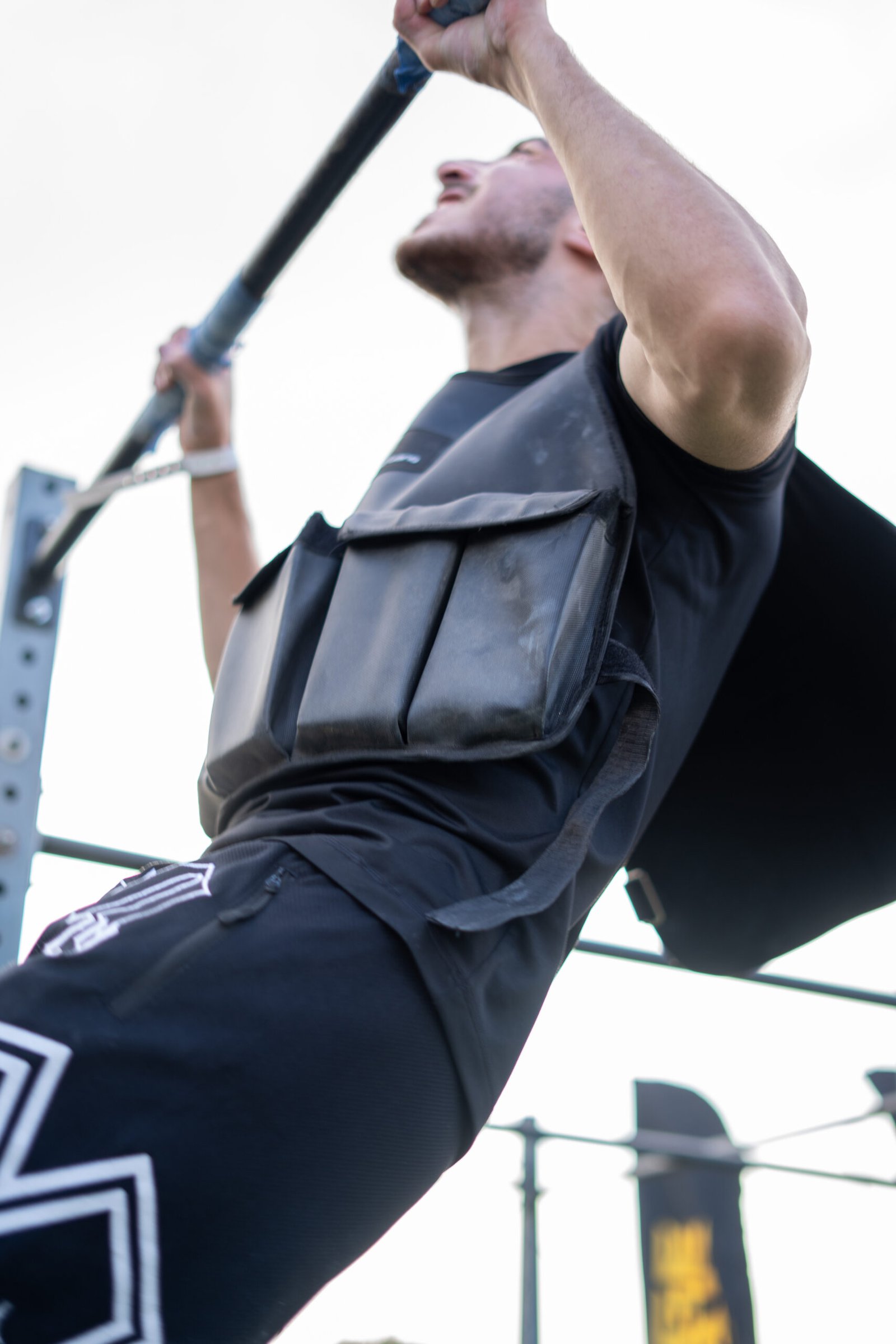 Man using a weighted vest during outdoor workout for strength training.