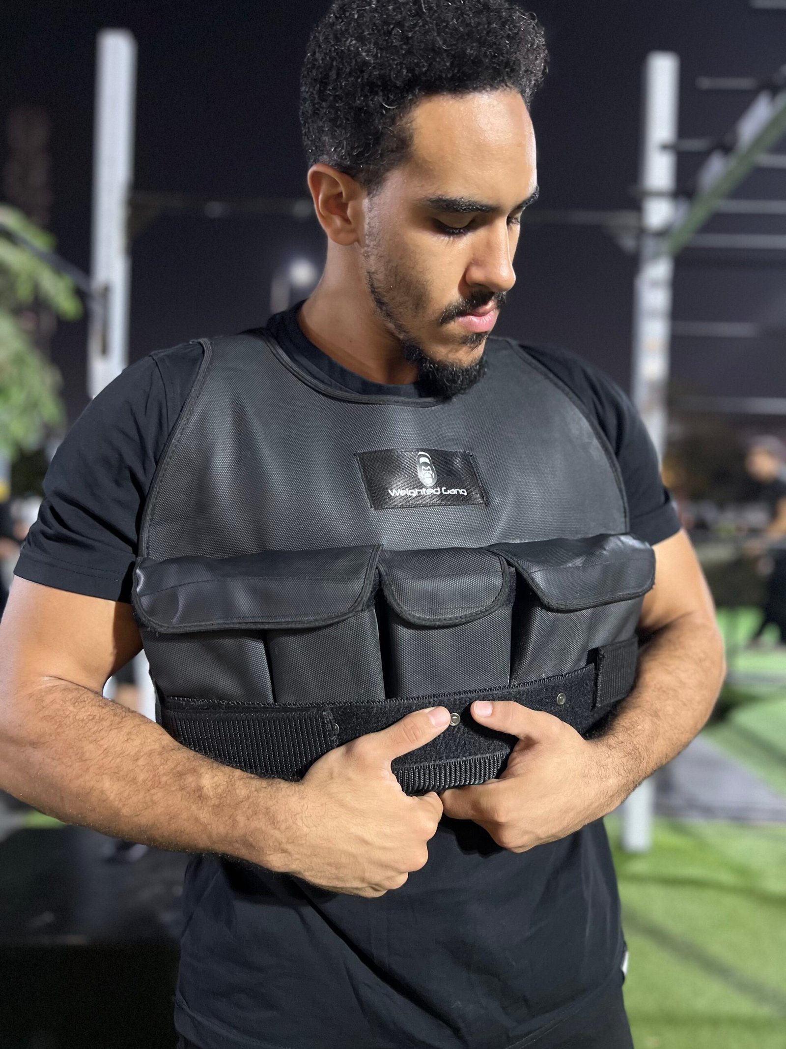 Man wearing a 10kg weighted vest during workout at gym.