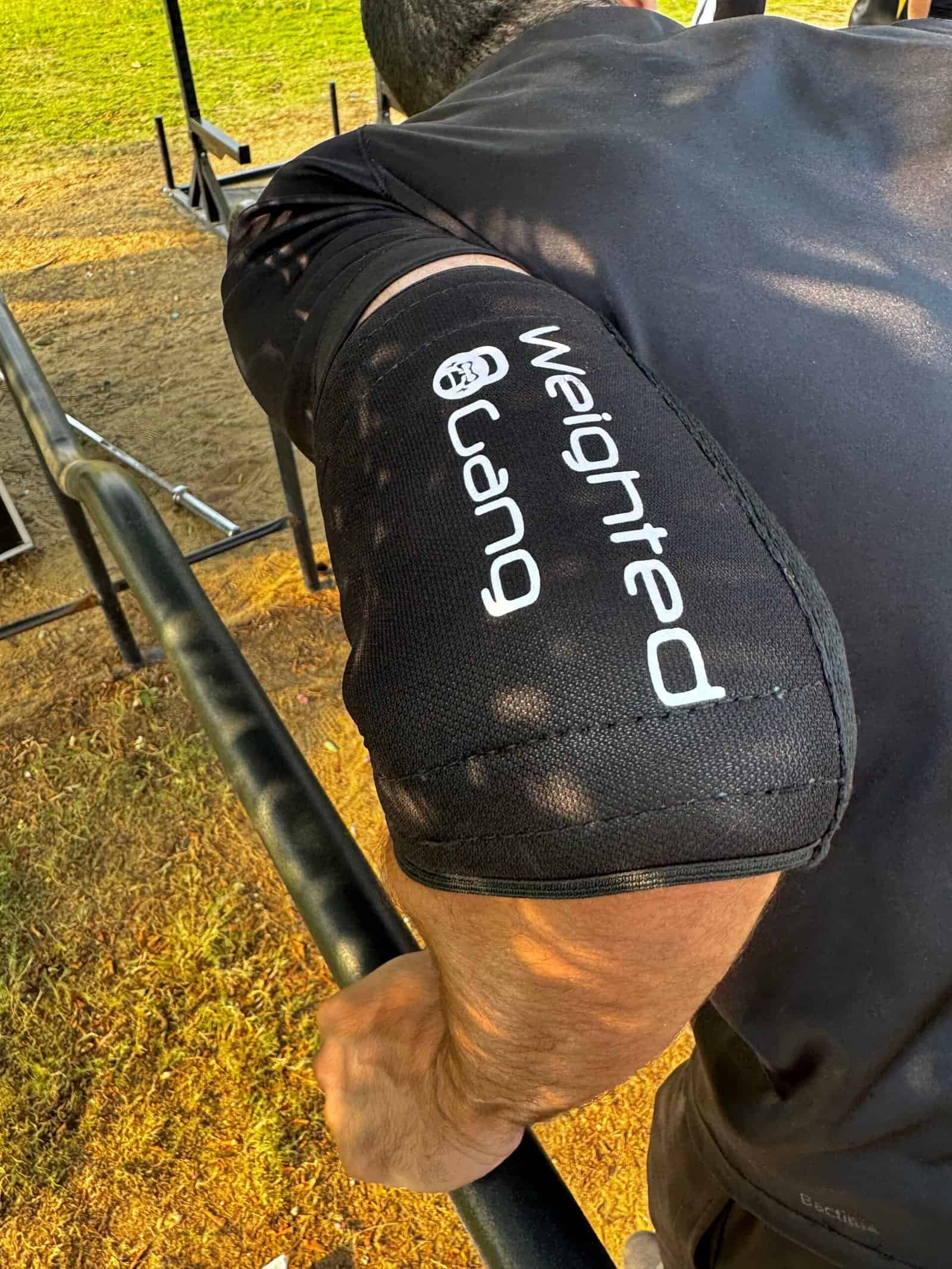 Close-up of a person wearing Weighted Gang elbow sleeves during workout.
