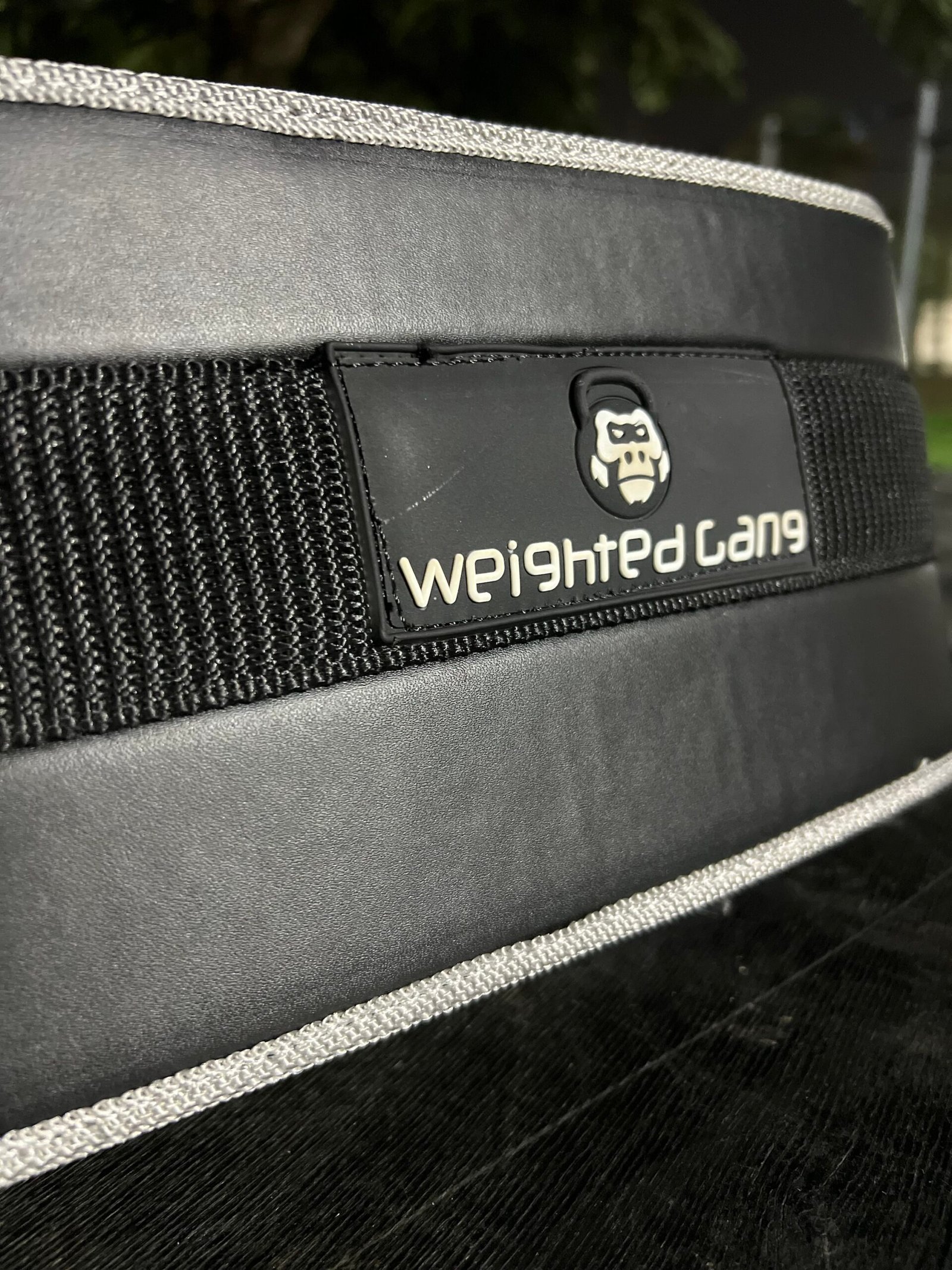 Close-up of a black weighted belt with Weighted Gang logo for fitness training.
